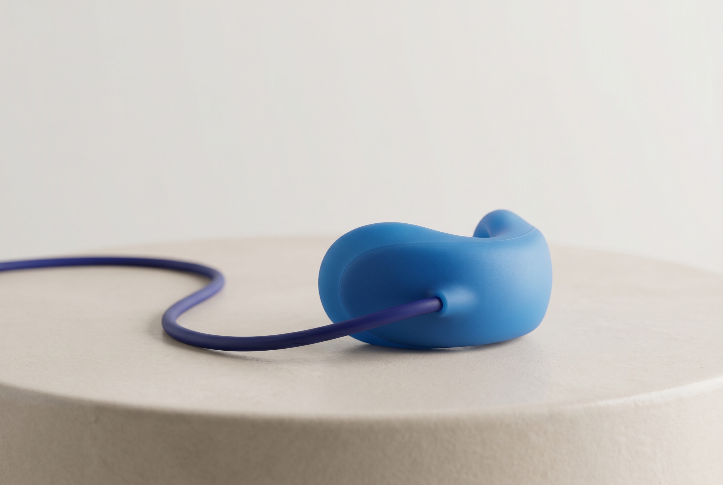 A soft blue silicone laughing-gas nose mask with a slim tube, resting on a clean light surface
